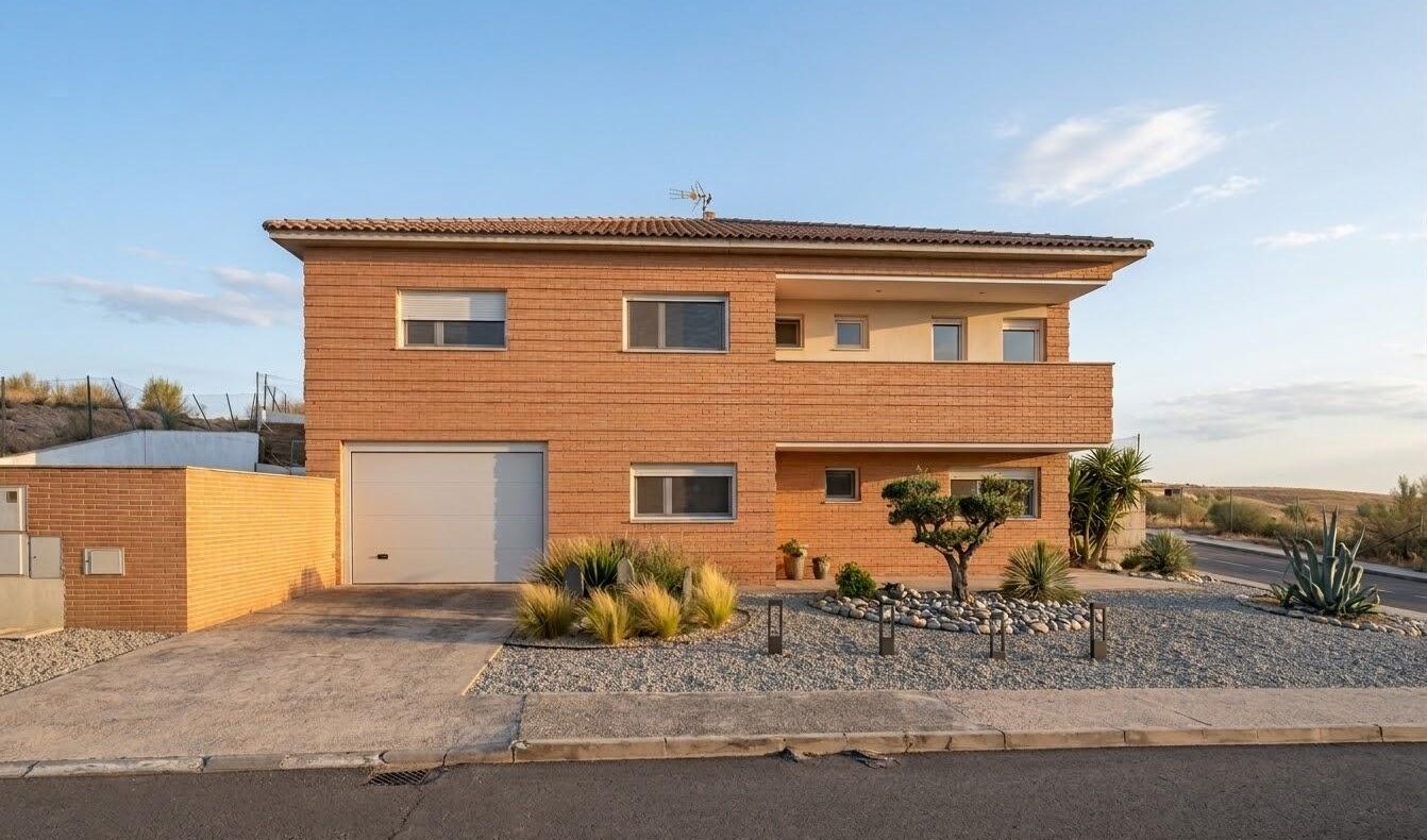 Modern brick two-story house with a single-car garage and a gravel drought-tolerant landscape in the front yard.